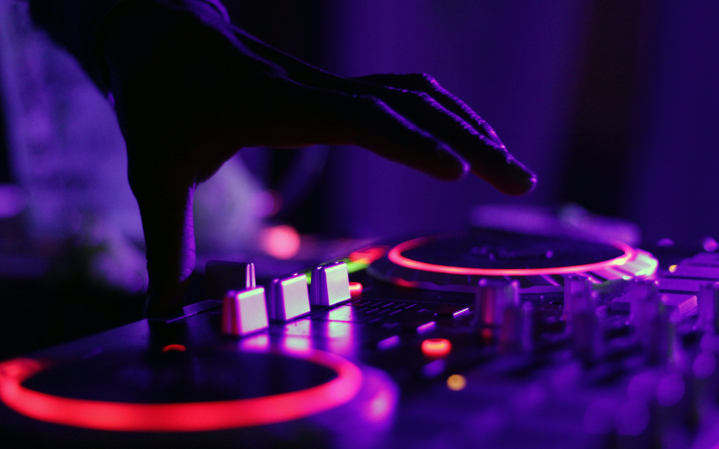 DJ im roten Clublicht am Pult